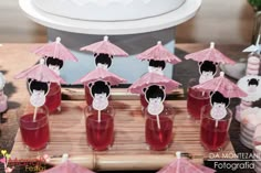 there are many small cups with drinks in them on the table and one is holding an umbrella