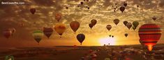 many hot air balloons flying in the sky