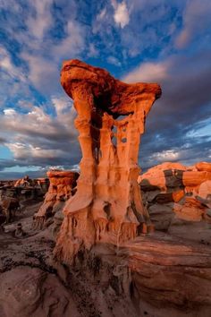 a rock formation in the desert under a cloudy sky