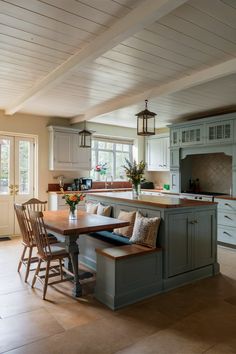 a kitchen with an island, table and chairs