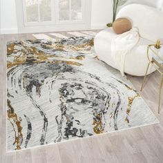 a white rug with gold and black designs on it in a room next to a chair