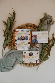 the wedding stationery is laid out on a wicker basket with leaves and ribbons