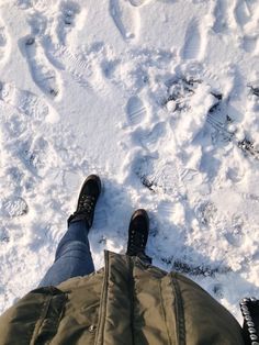 someone is standing in the snow with their feet up