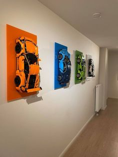 three brightly colored cars mounted to the side of a wall