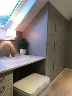 a room with a desk, drawers and a lamp on top of the table in front of it