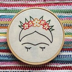 a close up of a embroidery on a piece of fabric with a small flower in the center