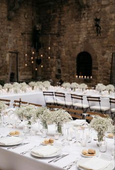 the tables are set with white flowers and place settings