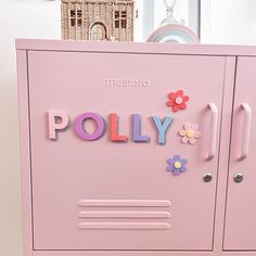 a pink locker with the word pollly spelled in multicolored letters on it