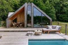 a house with a pool in the middle and wooden decking on it's side