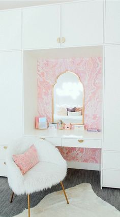 a white chair sitting in front of a desk with a mirror on top of it