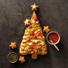 a christmas tree shaped pastry next to some dipping sauce