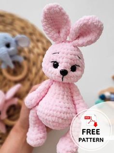 a pink crocheted stuffed animal sitting on top of a table next to a basket