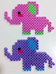 two pieces of lego art made to look like elephants, one is pink and the other is blue