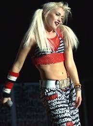 a woman with long blonde hair wearing a red and white top is performing on stage