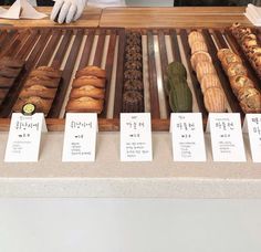 a display case filled with lots of different types of breads and pastries next to each other