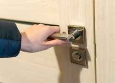 a person opening a door with a key in their hand