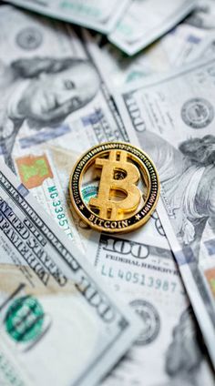 a bitcoin pin sitting on top of dollar bills stock photo edit to see more images