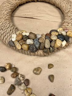 a close up of rocks on a table near a roped wreath with stones in the middle