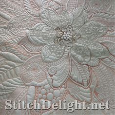 a close up view of a quilted fabric with flowers and leaves in the center