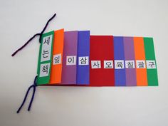 an assortment of colorful books with chinese characters on the covers and string attached to them