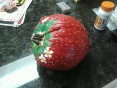 a large red strawberry sitting on top of a counter