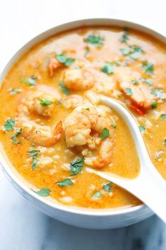 a white bowl filled with shrimp and rice soup