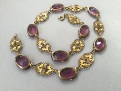 "Czech oval amethyst glass bezel/prong set cabochon collar. Wonderful Art Deco necklace that could have been made in the 20's or 30s. This is most likely made in the 1930s. Unusual bezels capture the colored glass gems that are in tandem with gilt brass filigree planks. Truly appealing necklace. This could be the antique necklace for you. Lovely condition but does show some slight greening on a couple of the gilt filigree pieces. Please look carefully. One of my favorites! 14 1/2\" long Glass an Vintage Oval Jeweled Necklaces, Vintage Oval Jeweled Necklace, Vintage Jeweled Oval Necklace, Antique Oval Cabochon Gemstone Necklaces, Oval Filigree Necklaces For Formal Occasions, Formal Oval Filigree Necklace, Vintage Hallmarked Oval Cabochon Necklace, Art Deco Oval Necklace For Formal Occasions, Art Nouveau Gemstone Necklaces For Formal Occasions