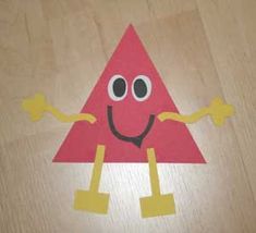 a piece of paper that has been cut out to look like a triangle with eyes and legs