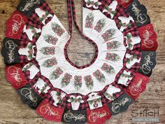 a christmas wreath made out of red and black plaid fabric on a wooden table top