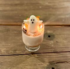 a small glass filled with liquid and decorated like a ghost