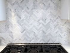 a stove top oven sitting inside of a kitchen next to a white counter top with marble tiles on it