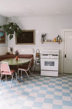 a kitchen with blue and white checkered flooring next to a stove top oven