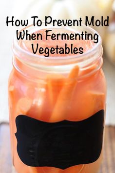 a jar filled with pickled vegetables on top of a wooden table next to a knife