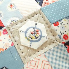 a patchwork quilt with an ornament in the center and flowers on it