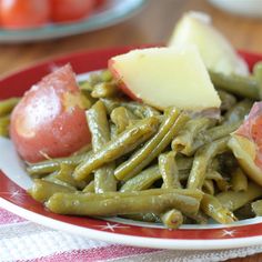 green beans, potatoes and tomatoes on a red and white plate with a checkered table cloth