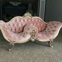 a pink couch sitting on top of a carpeted floor