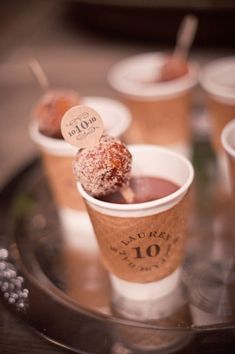 three cups filled with desserts on top of a black tray next to each other