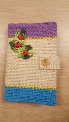 a crocheted cloth with buttons on it sitting on top of a wooden table