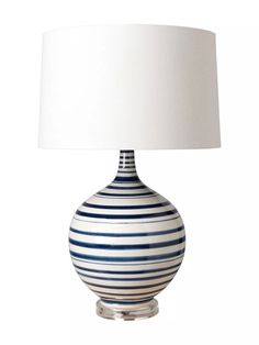 a blue and white striped lamp with a white shade on the top, sitting against a white background