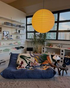 a living room filled with furniture and a large yellow lantern hanging over the top of it