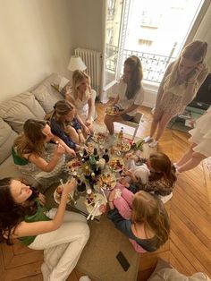 a group of women sitting around a table eating food