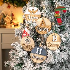 a christmas tree decorated with wooden ornaments and personalized name ornament hanging from it