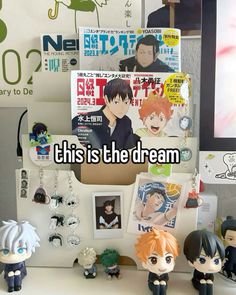 there are many anime figurines on the desk next to each other, including one with