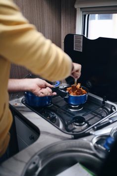 a woman is cooking food on the stove