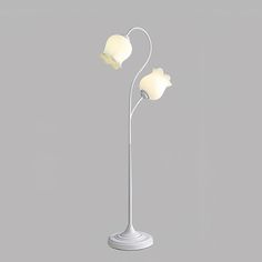 a white floor lamp with two flowers on it