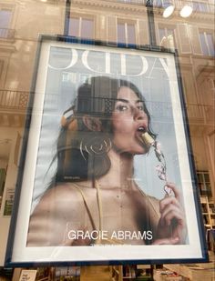 a large advertisement on the side of a building with an image of a woman brushing her teeth