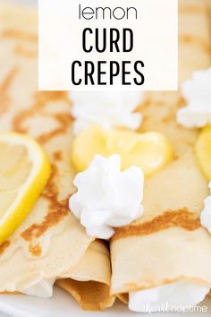 lemon curd crepes on a white plate topped with whipped cream and sliced lemons