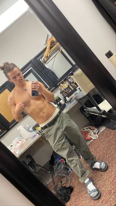 a man taking a selfie in front of a mirror with his shirtless body