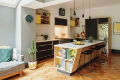 a kitchen with wooden flooring and yellow cabinetry next to a white counter top