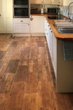 a kitchen with wooden floors and white cabinets